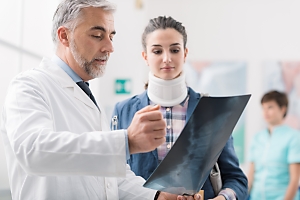 Doctor showing patient spinal cord injury xray
