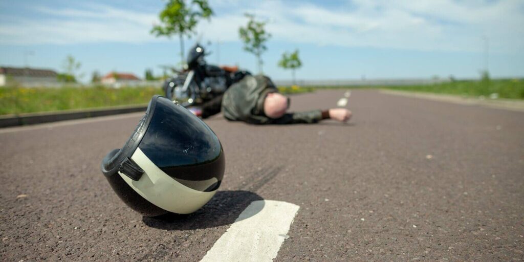 biker helmet lies on street near a motorcycle accident